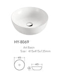 White round ceramic bathroom vessel sink with silver faucet and drain, perfect for modern countertop or vanity installations.