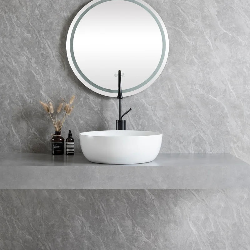 White round ceramic bathroom vessel sink with silver faucet and drain, perfect for modern countertop or vanity installations.