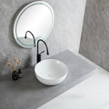 White round ceramic bathroom vessel sink with silver faucet and drain, perfect for modern countertop or vanity installations.